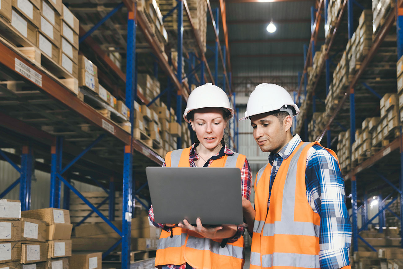 Two People in Warehouse looking at laptop