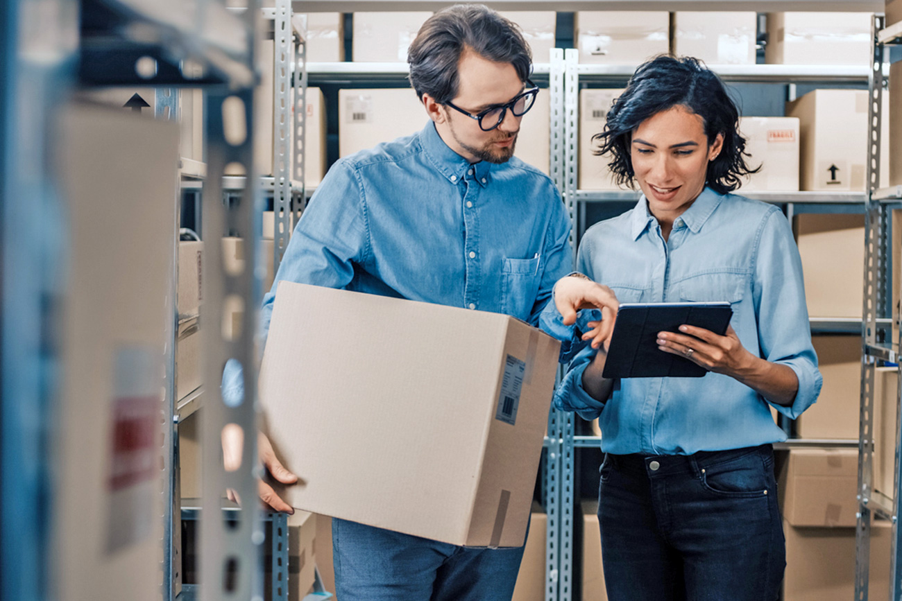 Two Coworkers in Warehouse looking at tablet