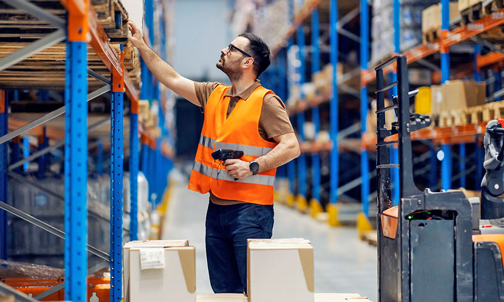 Man reaching on to pallet rack in warehouse