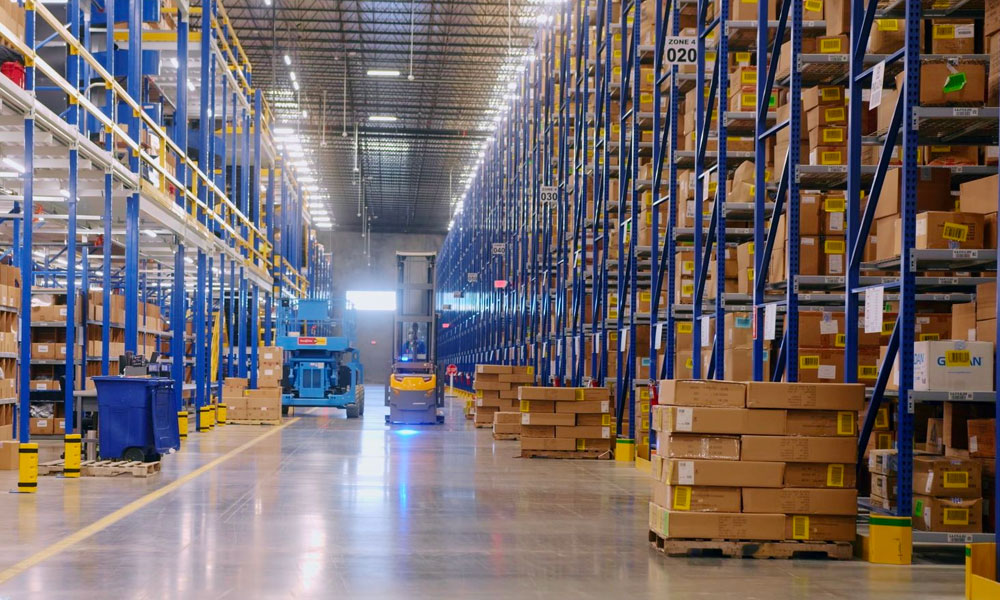 Narrow aisle forklift driving in warehouse between rows of racking